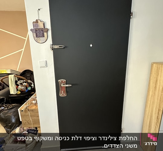 דלת שחורה עם ידית מתכת ובריח כסוף